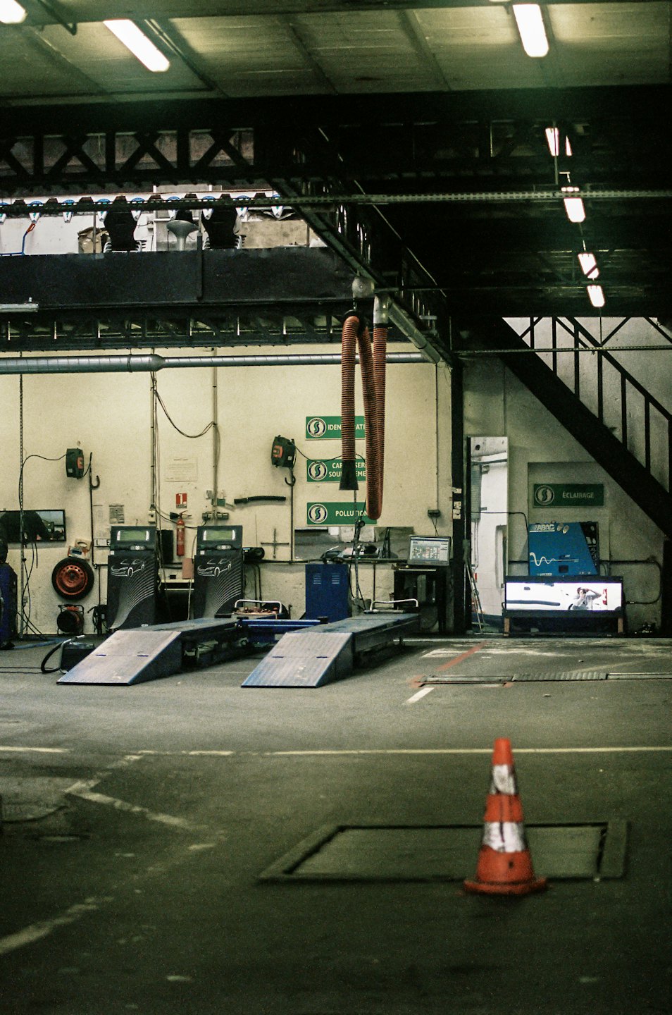 Automotive service garage with car inspection ramps and tools.